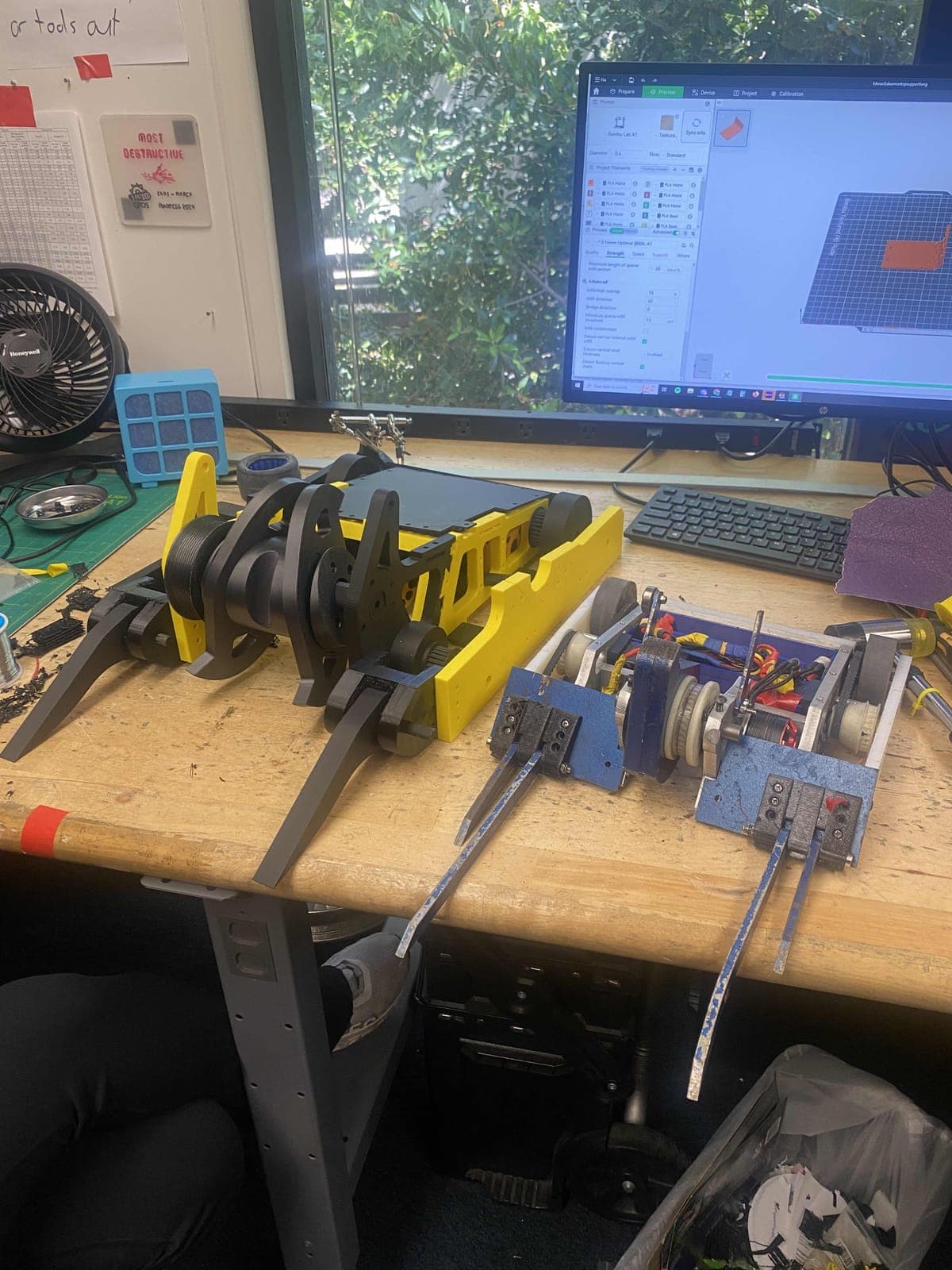 The 3D-printed Shear Force prototype on a bench next to a smaller 12 lb robot